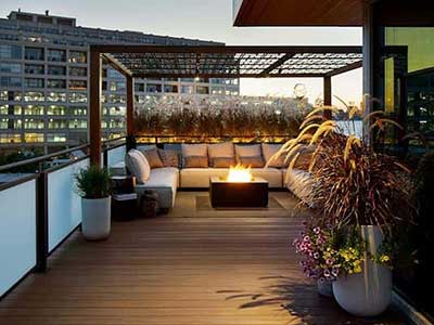 Elegant, elevated Azek deck at dusk with a firepit surrounded by a sofa
